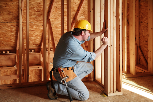 contractor working on wood frame of house